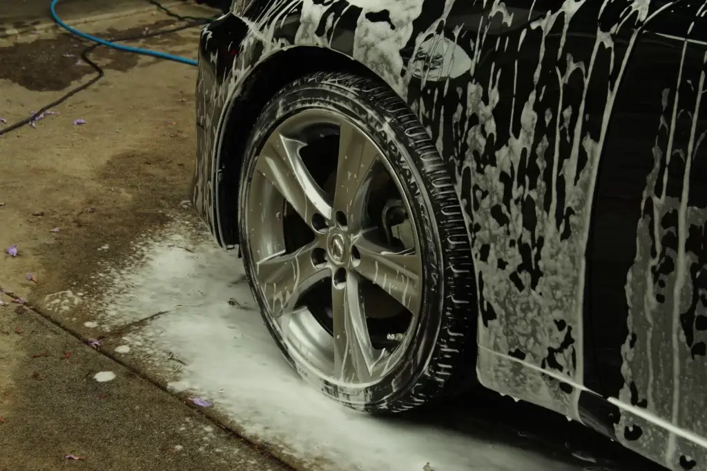 Alloy wheel covered in foam during a hand wheel clean