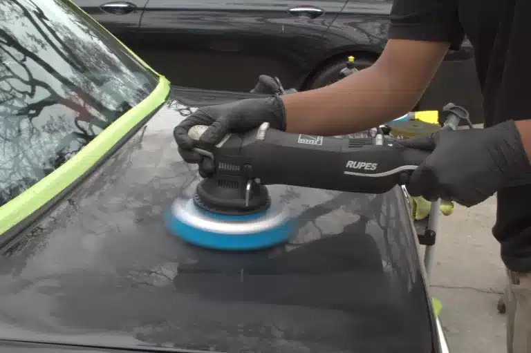 RUPES polisher working a taped-off panel during a two-step correction