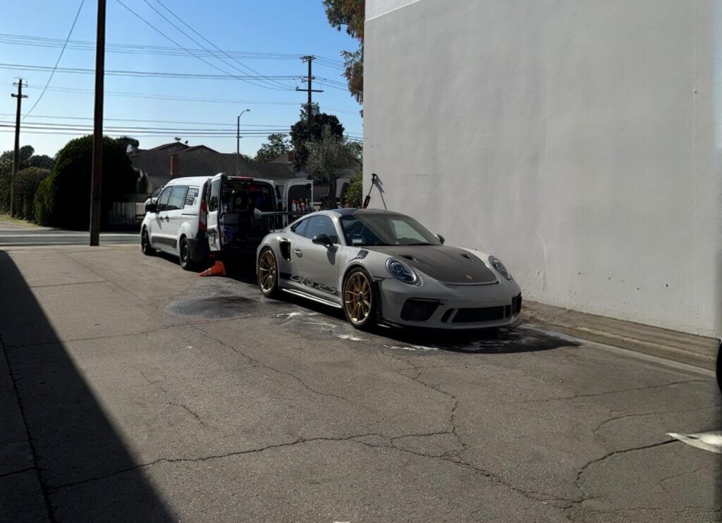 Silver Porsche 911 parked outside after a mobile maintenance wash