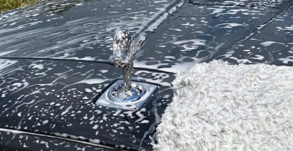 Rolls-Royce Spirit of Ecstasy hood ornament covered in wash foam during a full detail
